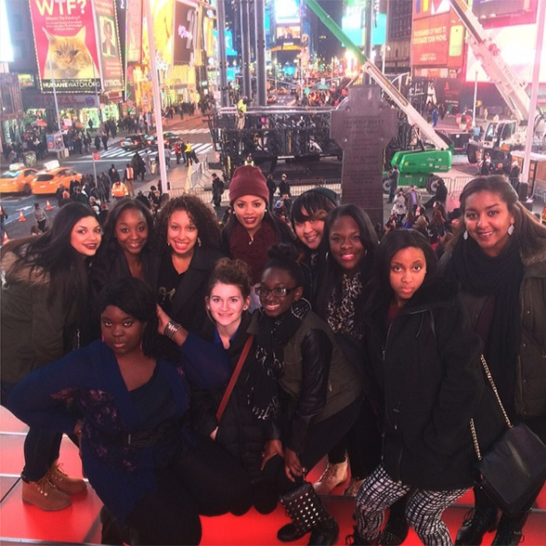 A large group of students posing for the camera in Time Square. 