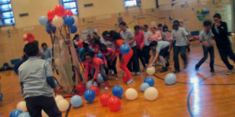 A big group of students playing with balloons. 