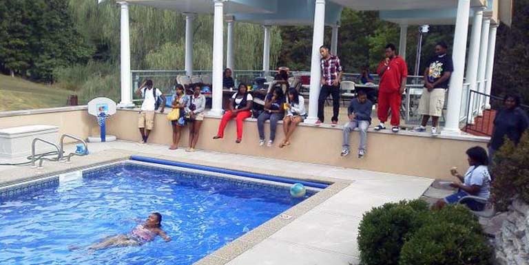 Students lounging beside a pool. 
