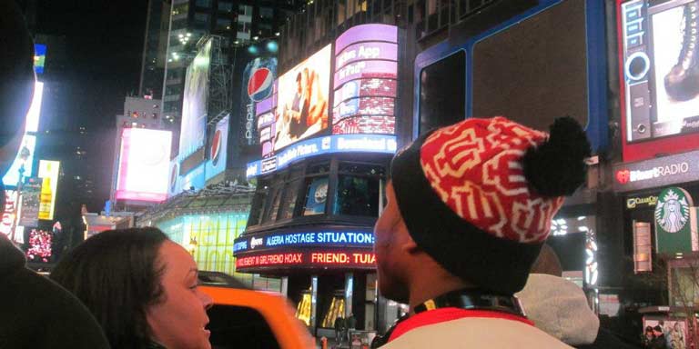 Over-the-shoulder image of two students exploring Time Square.