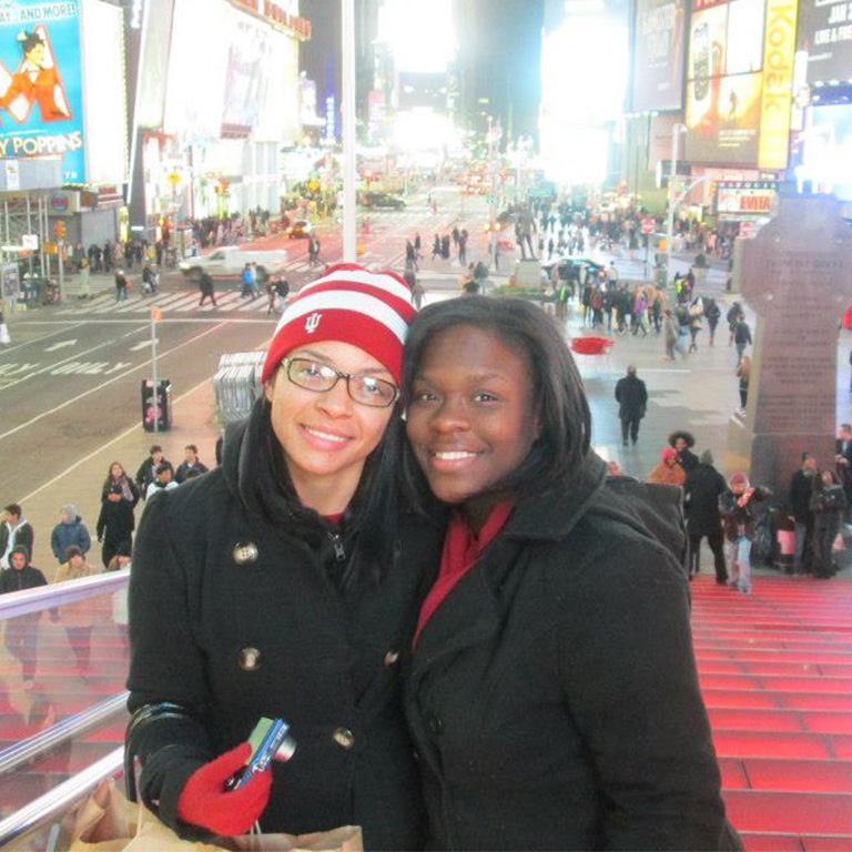 Two students posing for a picture together in Time Square. 